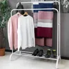 A white metal garment rack with clothes and scarves hanging on it, and shoes on the bottom shelf. Podgląd zdjęcia produktu