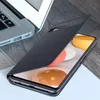 A black smartphone case is shown partially covering a smartphone, with a laptop in the background. Náhled obrázku produktu