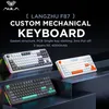 Three AULA F87 custom mechanical keyboards are displayed on a dark, tiered surface with colorful RGB lighting around their bases. The background is dark, with text overlay describing the product's features. Produktbild-Vorschau