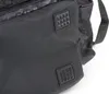 A close-up view of a black rucksack with camouflage detailing and textured studs. Produktbild-Vorschau