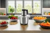 A kitchen counter with a food processor and bowls of fruits and vegetables. Anteprima dell’immagine prodotto