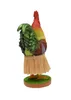 A figurine of a rooster wearing a grass skirt, standing on a green base. Produktbild-Vorschau