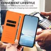 A person is holding an orange phone case with a phone inside, and a payment terminal is visible in the background. Náhled obrázku produktu