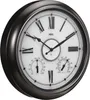 A close-up, angled view of a large, round wall clock with Roman numerals, a thermometer, and a hygrometer. Produktbild-Vorschau