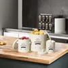 A set of three storage containers for vegetables on a wooden kitchen counter. Produktbild-Vorschau