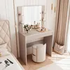 A bedroom scene featuring a vanity table with a mirror, makeup, and a stool, next to a bed and curtains. Produktbild-Vorschau