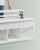 A person's hand is shown lifting the top of a white lift-top coffee table, revealing the hidden storage compartment. Náhled obrázku produktu