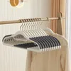 A set of gray, non-slip hangers are neatly arranged on a clothing rack. Voir les images du produit