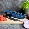 A knife sharpener with a knife, tomatoes, and onions on a wooden cutting board. Produktbild-Vorschau