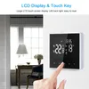 A hand is touching a digital thermostat mounted on a wall, with a room interior in the background. Podgląd zdjęcia produktu