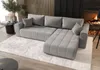 A modern living room with a gray sectional sofa, a fireplace with a fire, and a rug. Voir les images du produit