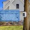 A digital electricity meter is mounted on a tree next to a house. Produktbild-Vorschau