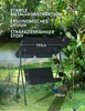 A black two-seater garden swing with a canopy, set up outdoors on a grassy area with trees and foliage in the background. Produktbild-Vorschau