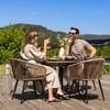 A couple enjoys a meal on a patio with a scenic mountain view. Produktbild-Vorschau