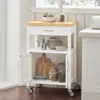A kitchen cart with a wooden top, drawers, and shelves, filled with kitchenware and decorative items, placed next to a window. Produktbild-Vorschau