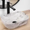 A marble-patterned sink with a black faucet on a wooden countertop. Náhled obrázku produktu
