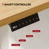 A smart controller for a standing desk, attached to the underside of a wooden desk. Voir les images du produit