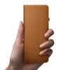 A hand holding a brown leather phone case. Produktbild-Vorschau