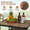 A table set with fruit and bottles of alcohol, with a chair and trees in the background. Produktbild-Vorschau