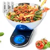 A digital kitchen scale with a bowl of tri-colored rotini pasta on top, surrounded by a few tomatoes and basil leaves. Produktbild-Vorschau