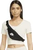 A woman wearing a white t-shirt and a black Nike fanny pack. Náhled obrázku produktu