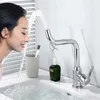 A woman is washing her face at a sink with a modern faucet. Produktbild-Vorschau