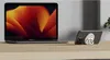 A laptop and a smartphone with a MagSafe accessory are placed on a wooden desk. Produktbild-Vorschau
