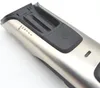 A close-up shot of the top part of a silver electric trimmer, showing the power button and length adjustment settings. Podgląd zdjęcia produktu