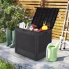 A storage box filled with garden tools and accessories is placed on a patio next to a watering can and a ladder. A wooden fence and lush greenery form the background. Voir les images du produit