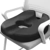 A black ergonomic seat cushion on a white and gray chair. Produktbild-Vorschau