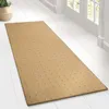 A beige runner rug with a grid pattern is laid out on a white wooden floor in a hallway, with a doorway and window visible in the background. Produktbild-Vorschau