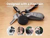 A black round smart tag attached to a set of keys and a car key fob, with four smaller inset images showing the tag attached to luggage, a backpack, a wallet, and keys. Anteprima dell’immagine prodotto
