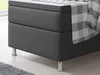 Close-up of the base of a bed with a blanket draped over it. Produktbild-Vorschau