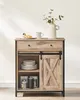 A rustic-style sideboard with a sliding barn door and stacked plates. Náhled obrázku produktu