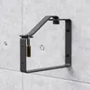 A black steel wall mount for a ladder, secured with a padlock, is attached to a concrete wall. Produktbild-Vorschau