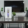 A water filter and hydrogen ionizer is placed on a table in front of a large screen TV. Produktbild-Vorschau