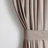 A close-up view of a beige velvet curtain with pleats and a tie-back. Produktbild-Vorschau