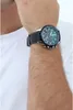A person wearing a white t-shirt and a watch on their wrist. Náhled obrázku produktu