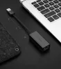 A black USB to RJ45 adapter is shown on a black surface next to a laptop. Voir les images du produit