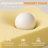 A close-up of yellow memory foam with a white sphere demonstrating its ability to conform to pressure. Produktbild-Vorschau