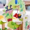A close-up of a wooden toy with colorful illustrations of fruits and birds, featuring a red bell and a transparent sphere with a bird illustration. Anteprima dell’immagine prodotto
