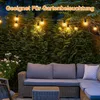 Outdoor patio furniture with string lights at night. Produktbild-Vorschau