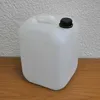 A white plastic water canister with a black cap sits on a wooden surface against a textured white wall. Anteprima dell’immagine prodotto