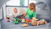 A mother and baby are playing with toys inside a playpen. Anteprima dell’immagine prodotto