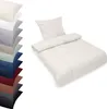 A stack of folded bedding in various colors is shown on the left, and a cream-colored duvet and pillow set is displayed on the right. Produktbild-Vorschau