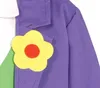 A close-up of a child's costume, showing a purple jacket with a yellow flower pin and a green vest underneath. Anteprima dell’immagine prodotto