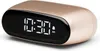 A close-up studio shot of a gold-colored digital alarm clock with a black display showing the time. Náhled obrázku produktu