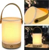A collage of images showing a portable LED lamp with a wooden base and fabric shade, in different settings. Produktbild-Vorschau