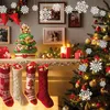 A festive Christmas scene with a decorated tree, stockings, and ornaments on a mantelpiece. Produktbild-Vorschau