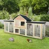 A wooden rabbit hutch with two small animals in the foreground on a grassy lawn, with lush greenery in the background. Voir les images du produit